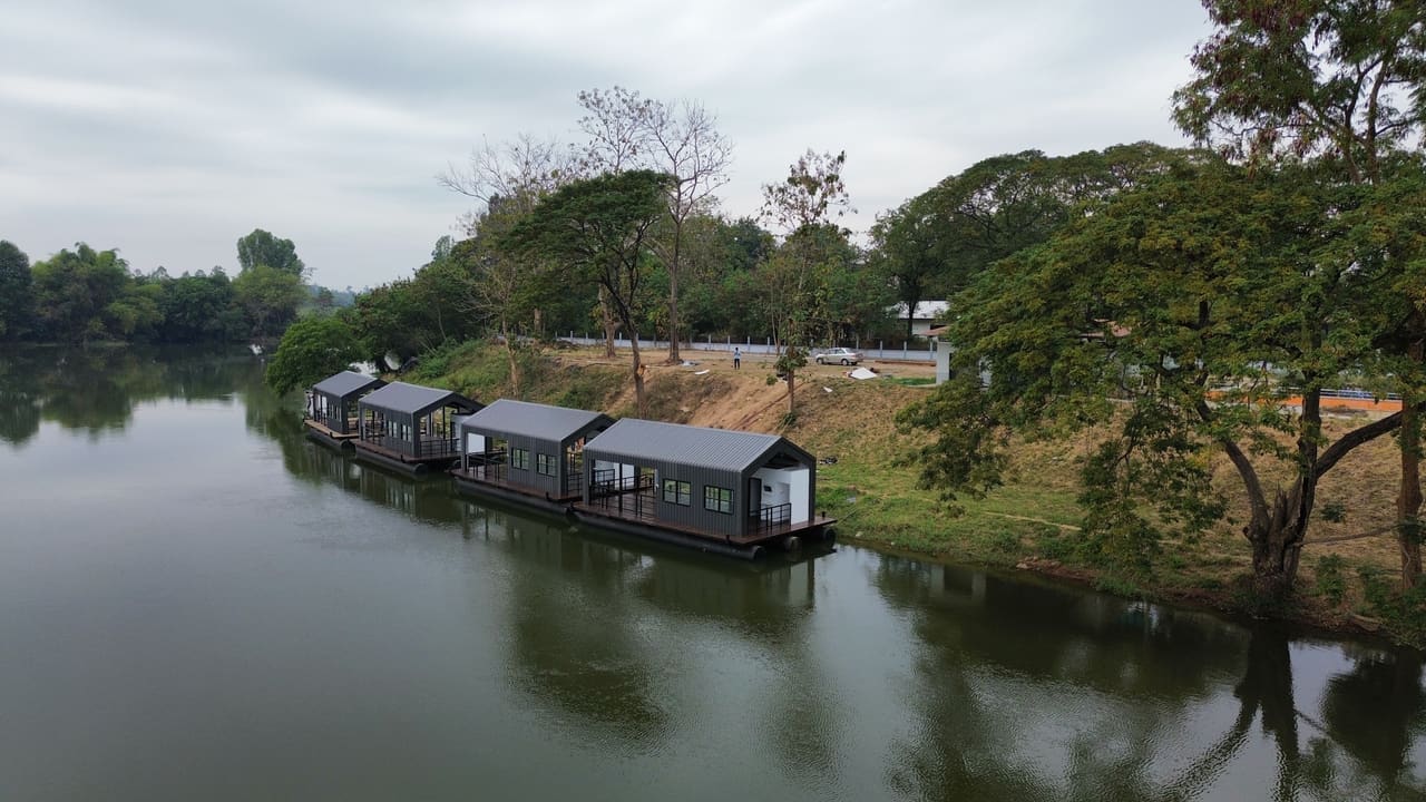 แพที่พักลอยน้ำหลายหลังจอดเรียงริมฝั่งแม่น้ำ มุมกว้าง — แพที่พักล่องในลำน้ำ เขื่อน แม่น้ำ T.K.M. Aquatic